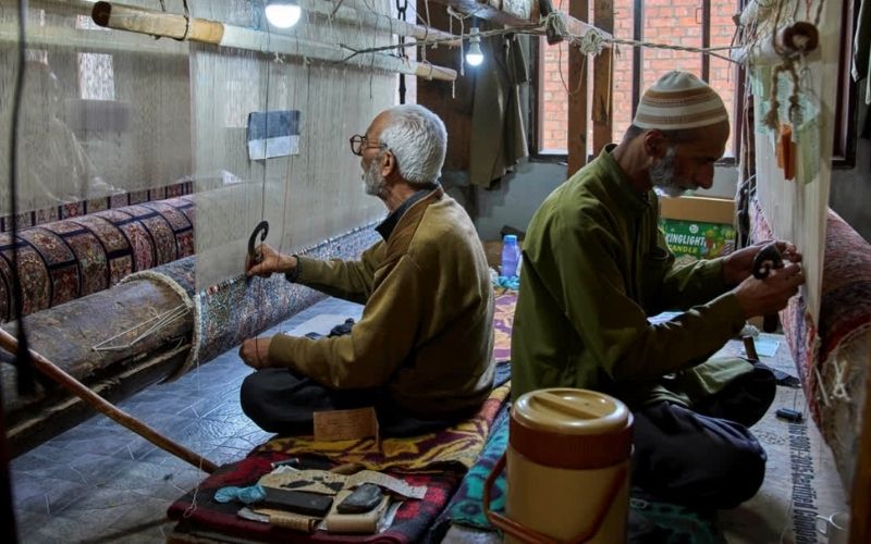Kashmiri men weaving carpet